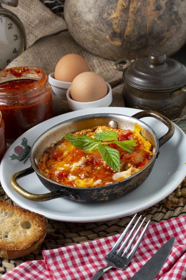 Sahan içinde fesleğenle servis edilen menemen