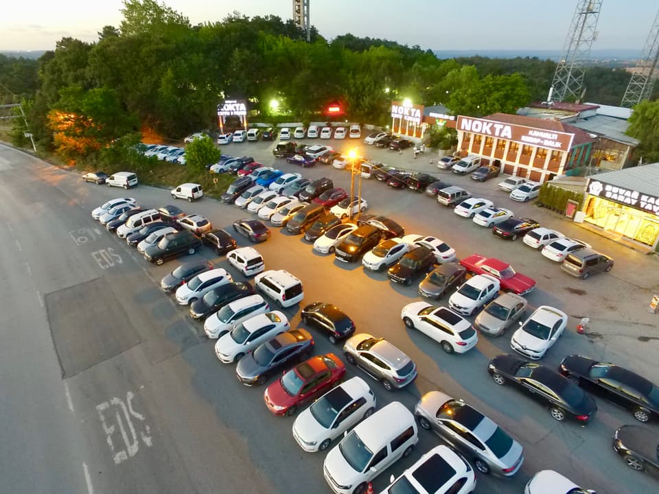 Akşam saatlerinde yukarıdan görünen geniş otopark ve tesis
